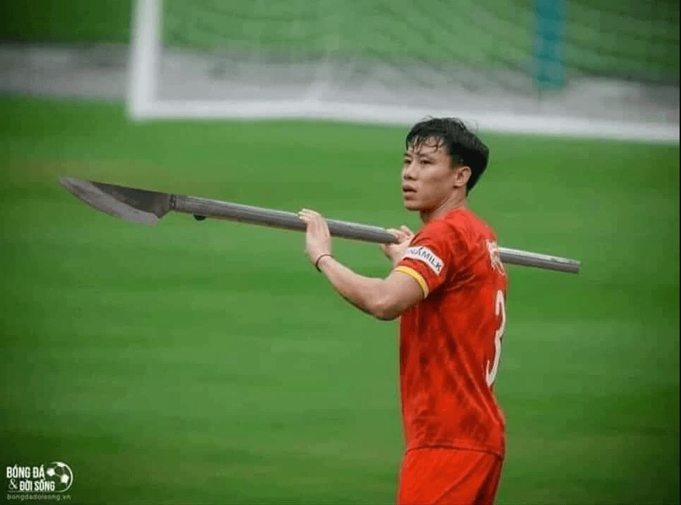 Quế Ngọc Hải cầm phóng lợn tạo dáng trên sân