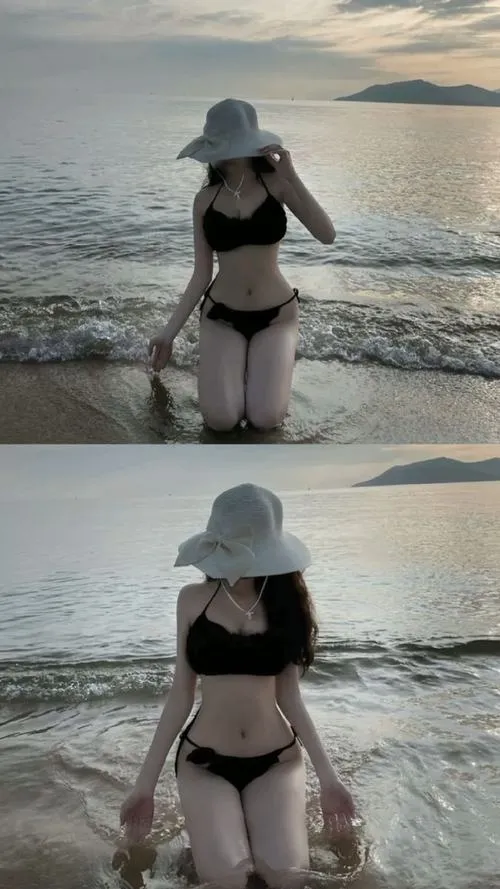 Ảnh cô gái bikini sáng ngồi bên bờ biển, tóc xõa dài che kín mặt trong ánh hoàng hôn.