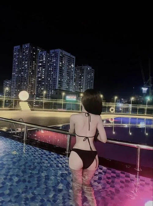 Ảnh bikini nghệ thuật che mặt của cô gái mặc bikini trắng nằm thư giãn trên ghế dài.