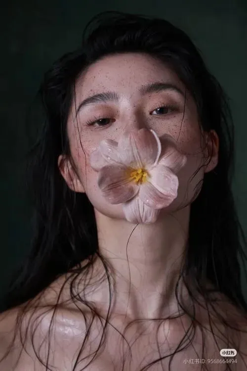 Người mẫu ngồi trên sàn với chân duỗi, tay chống sau lưng và mái tóc buông tự do.