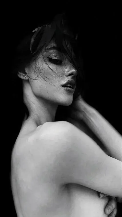 Gái xinh đứng bên khung cửa lớn, thân hơi xoay nghiêng ánh mắt nhìn xuống với vẻ mặt thanh thản và da sáng.