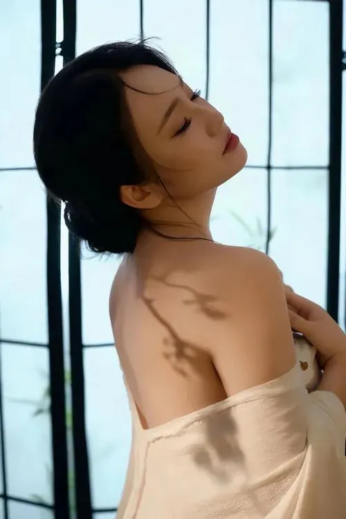 Cô gái đứng nghiêng người, chân chéo nhẹ và biểu cảm tự tin trong hình ảnh thiếu nữ không trang phục.