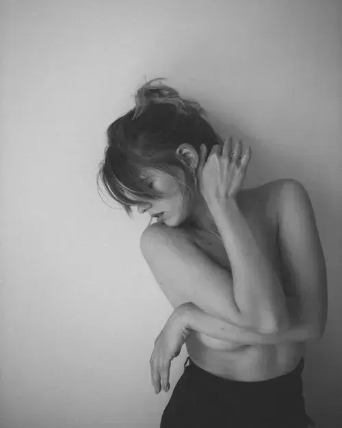 Thiếu nữ nằm ngửa dang tay nhẹ, đôi chân duỗi thẳng và không khí yên tĩnh bao quanh thân hình cân đối trong studio.