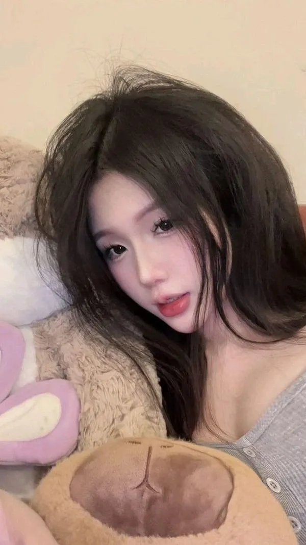 Ảnh mỹ nhân nằm nghiêng trên gối nâu, áo len xám để tóc xõa rơi qua má khiến bức cận cảnh có nét say đắm rất đời thường