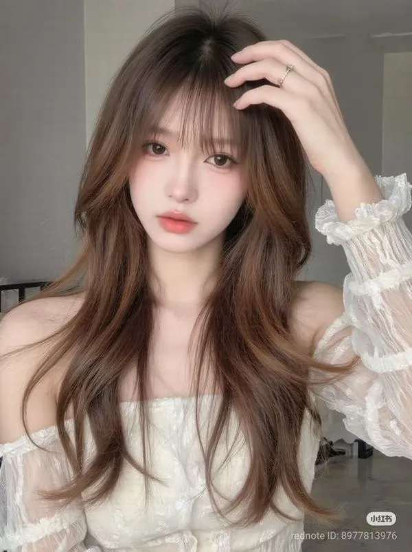 Cô gái mặc váy trắng bèo tay dài đưa tay lên tóc, gương mặt nhỏ và góc chụp cận khiến khung ảnh mang vẻ mịn màng rất hợp nhìn lâu