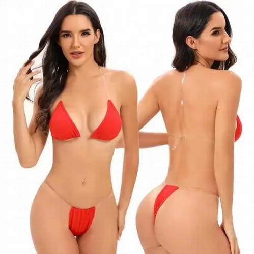 Người đẹp đứng giữa cánh đồng cát với bikini đen, một tay che nắng, ánh sáng mạnh làm nổi rõ từng đường nét cơ thể