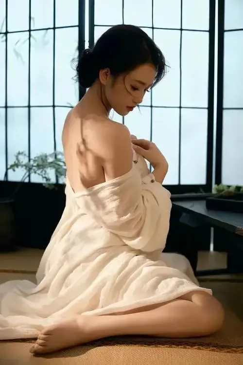 Cô gái đứng quay nghiêng hoàn toàn, tay buông dọc và đường cong hông eo hiện rõ mượt mà.