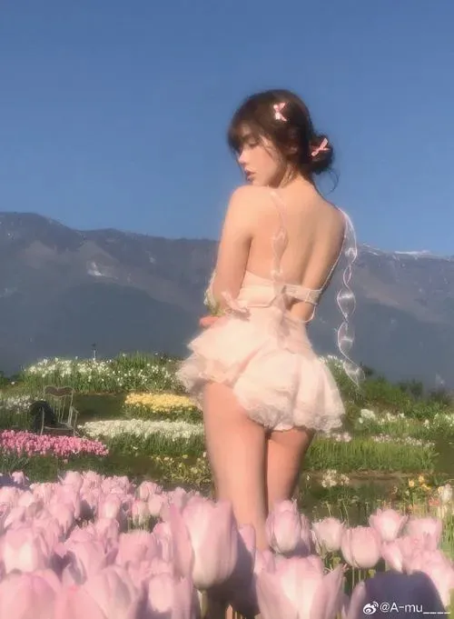 Cô gái nằm sấp với chân hơi nâng, bờ vai và lưng mịn màng trong tông màu ấm áp.