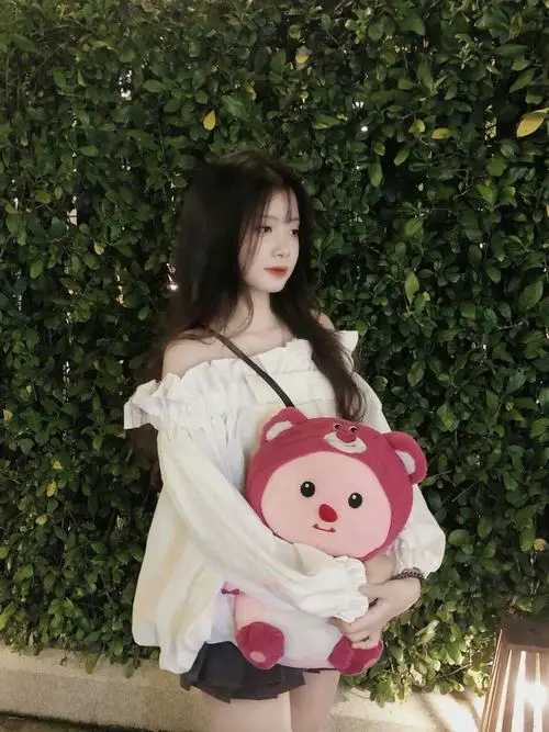 Cô gái trẻ búi tóc cao để lộ phần cổ trắng ngần, mặc chiếc áo yếm duyên dáng đứng bên hiên nhà cổ tạo nên một vẻ đẹp vô cùng đằm thắm