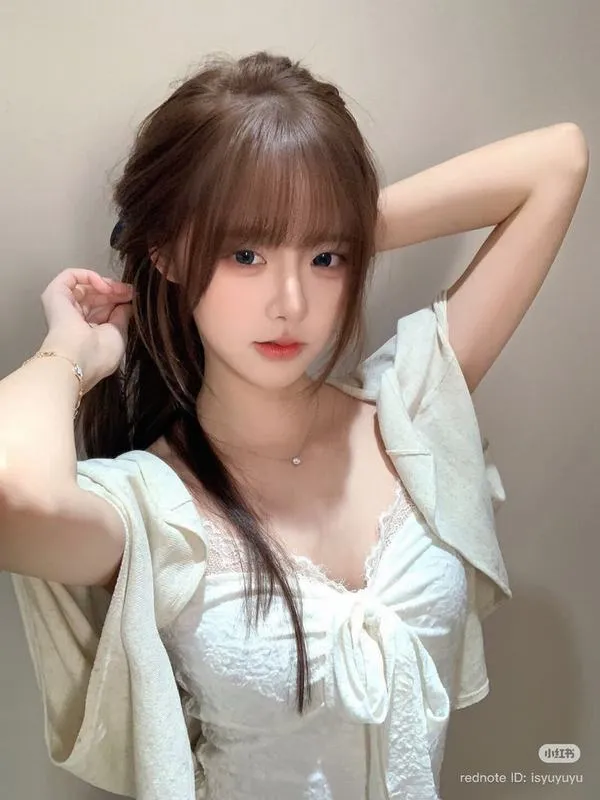 Buổi tối ở hội chợ, cô gái chọn một chiếc vòng thủy tinh dưới dải đèn vàng, tay áo voan hồng chạm cổ tay trông mơ màng rất hợp cảnh