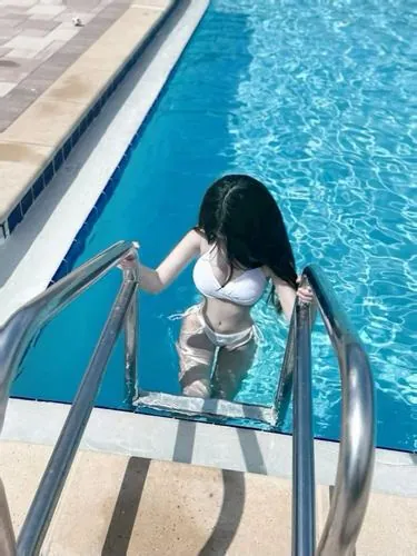 Cô nàng ngồi trên cát khô, tóc xõa tự nhiên, đồ bơi trắng tinh khôi giúp tổng thể trông nhẹ nhàng và dễ chịu