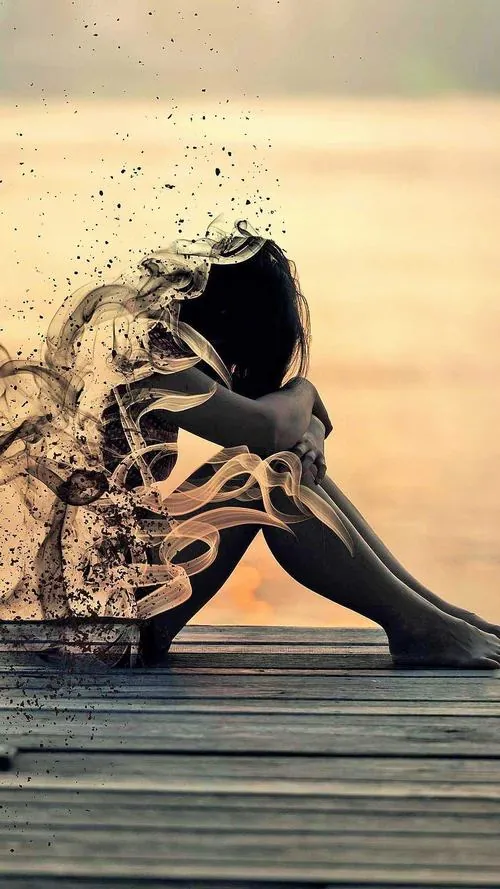 Thiếu nữ ngồi nghiêng trên bậc gỗ sát mép biển, hai tay ôm gối, váy tối và ánh chiều vàng nhạt khiến gương mặt trông u sầu hơn