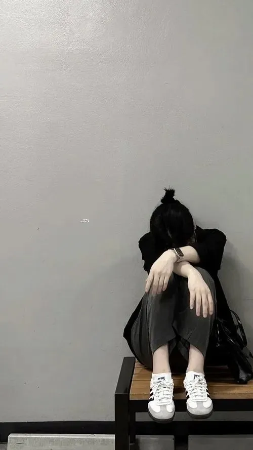 Avatar tâm trạng nữ cô gái mặc đồ trắng ngồi bó gối trong góc tường trống, đầu vùi xuống và khoảng nền xám rộng gợi không gian tĩnh