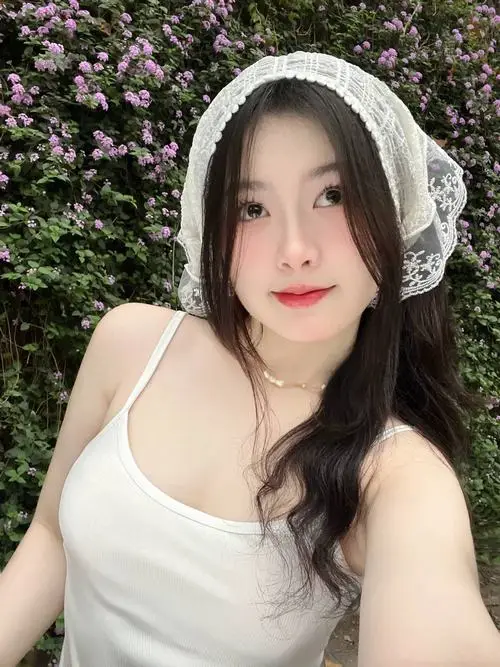 Dưới cơn mưa phùn nhẹ, cô gái cầm chiếc ô trong suốt bước đi chậm rãi trên phố, vẻ mặt ưu tư thoáng qua mang lại cảm giác mong manh dễ vỡ