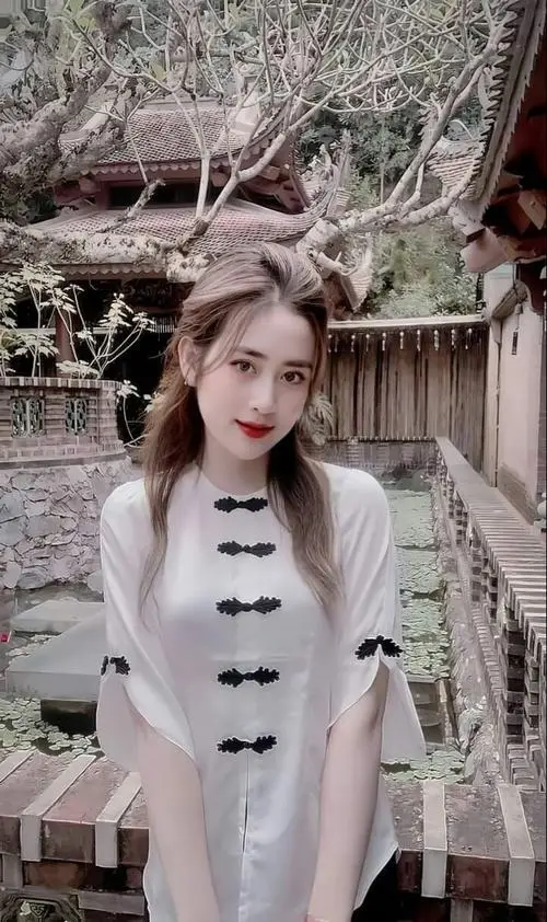 Gái xinh thắt bím tóc hai bên mặc đồng phục học sinh đứng giữa sân trường đầy nắng, nụ cười rạng rỡ khiến cả không gian bừng sáng vẻ hồn nhiên