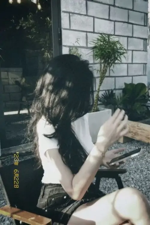 Gái xinh đeo túi máy ảnh nhỏ bước trên sàn gỗ của nhà ga cũ mái vòm cao phía trước mở ra khoảng sáng lớn khiến dáng lưng nổi bật