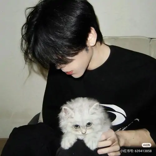 Avatar nam cậu trai ôm chú chó trắng trước ngực, mắt cúi xuống mái lòa xòa, khung sáng dịu làm tấm ảnh vừa dễ thương vừa rất người thật