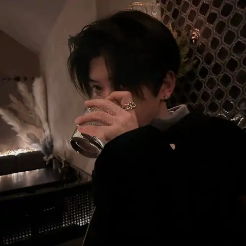 Tải ảnh avatar cậu bạn tóc nâu ngồi gần quầy lưới, bàn tay ôm ly sát môi, nền tối và góc gần làm tấm này ngầu kiểu người thật