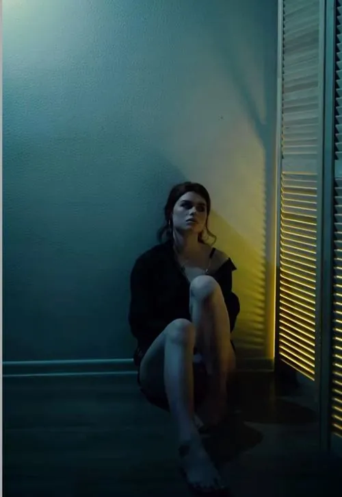 Thiếu nữ cầm chiếc máy ảnh phim đứng giữa ruộng mía cuối mùa, mắt nhìn xuống cuộn phim rối và gió hanh làm áo sơ mi bạc màu phấp phới