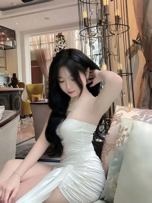 Thiếu nữ ngồi xổm bên lan can ban công mặc áo len mỏng màu be, tóc xõa tự nhiên, ngẩng mặt lên trời với nụ cười ngọt ngào và làn da sáng mịn.